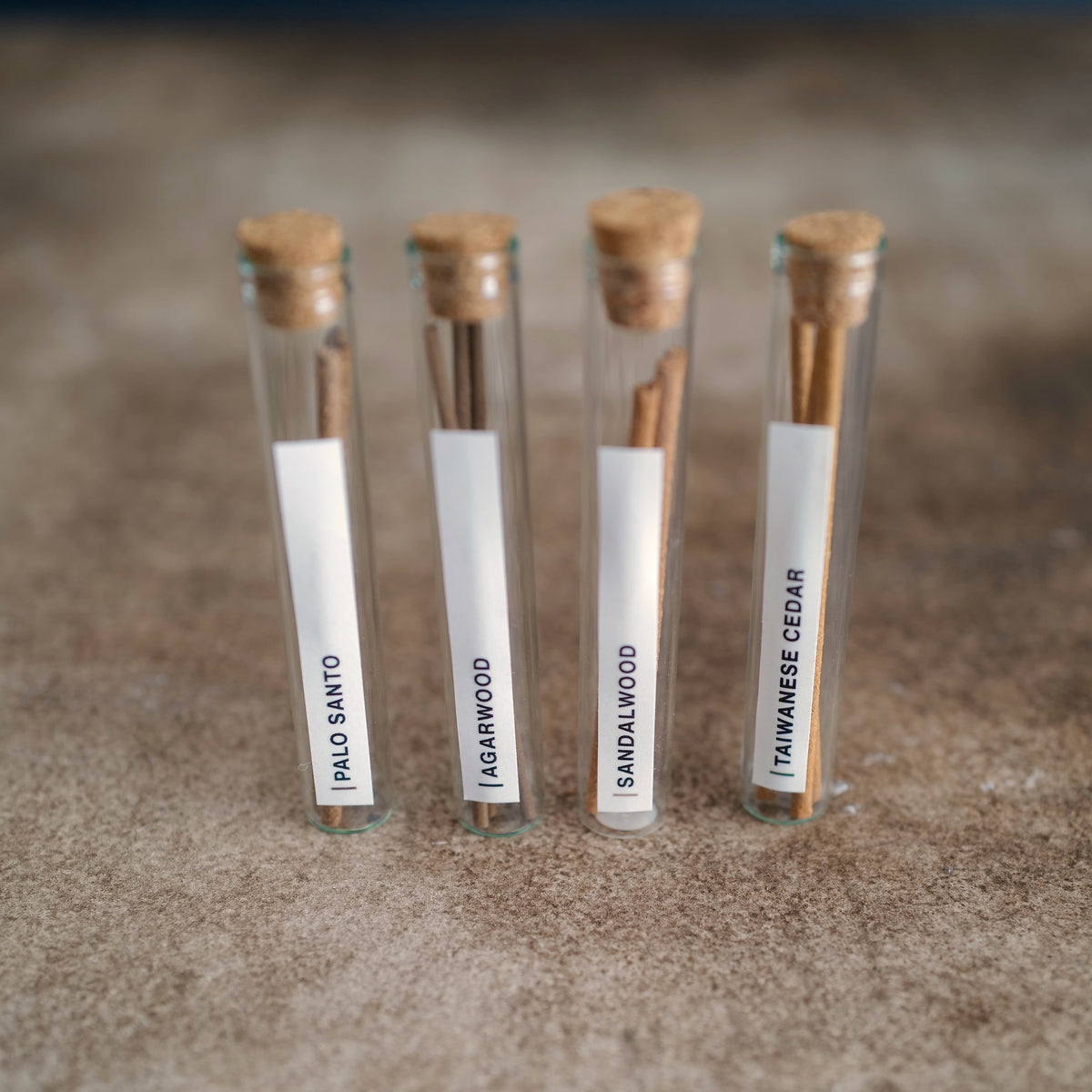 Incense sticks scent samples in four labeled glass vials
